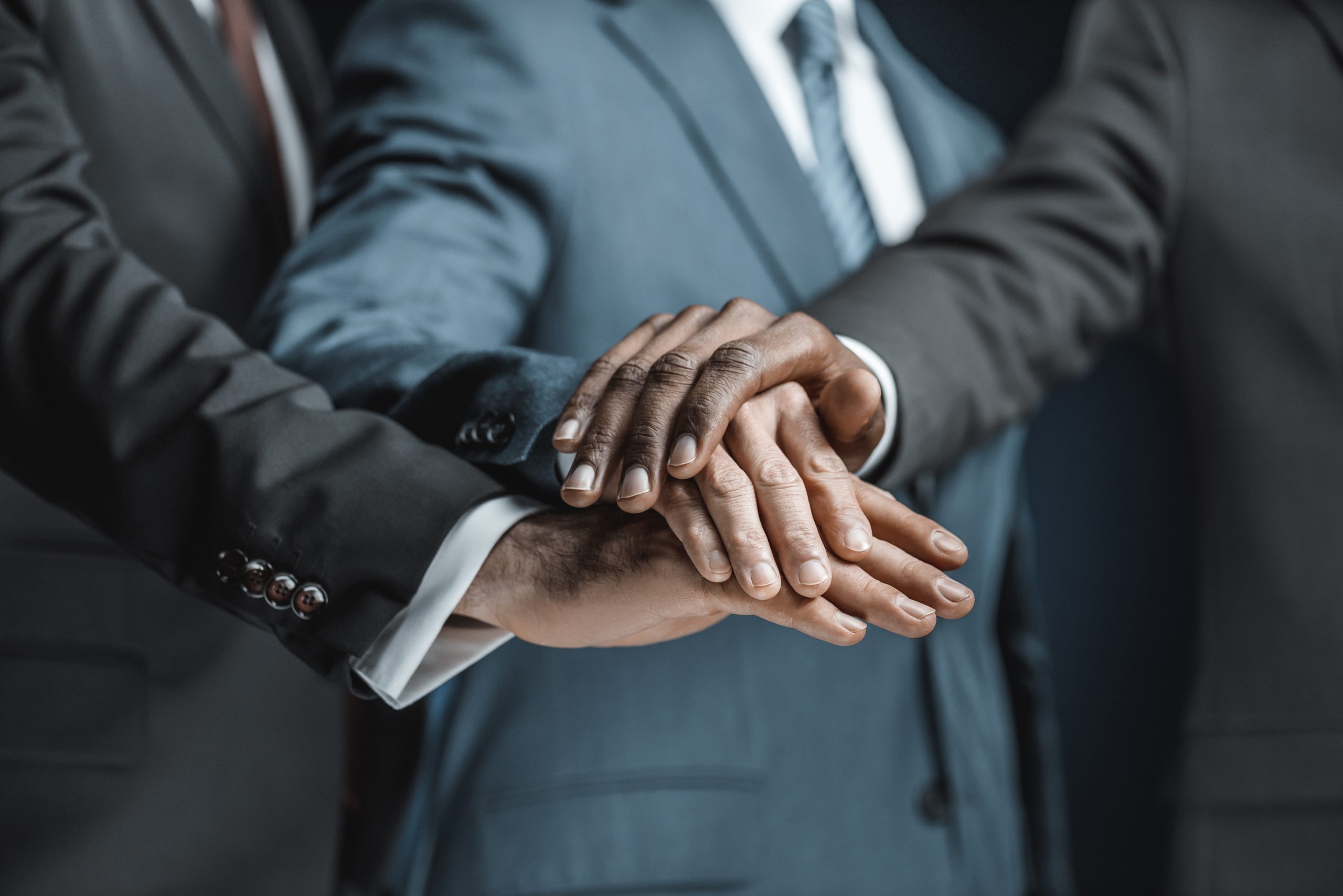 shot of businessmen holding hands together elevating partnership with tailored Loyalty Strategies